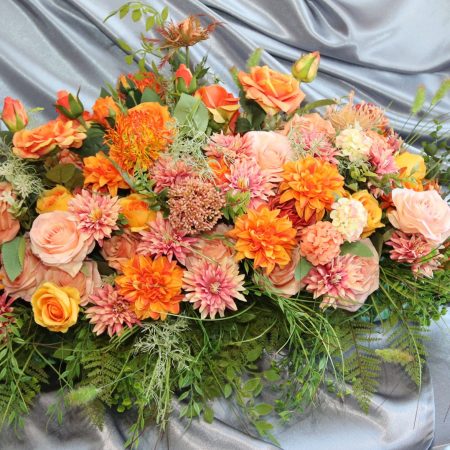 Orange and peach rose with hydrangeas casket spray