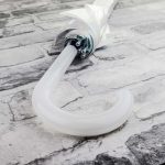 Broken white umbrella lying on a textured stone floor.