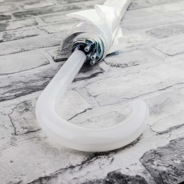 Broken white umbrella lying on a textured stone floor.