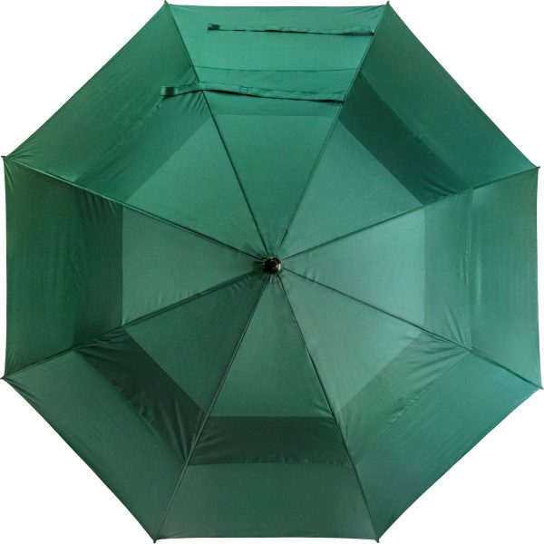 Green wind-resistant golf umbrella for outdoor use.