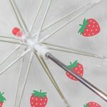 Children's umbrella with strawberry print design and clear dome canopy.