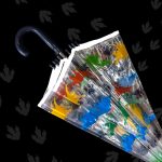 Colourful dinosaur-themed children's umbrella with clear dome design.