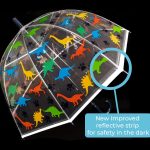 Transparent umbrella with colourful dinosaur patterns and reflective strip for safety.
